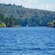 Wide lake view showing open water, distant treed shoreline and a small sailboat — good overall scenic overview of the campground’s lake frontage (image hosted on the property site’s homepage).