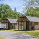 Small cottage/cabin units with an RV in background — shows lodging options and campsite adjacency (site/gallery imagery).