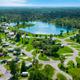 High, wide aerial view showing the resort layout: central lake, campsites, RV pads, roads and cabins consistent with HTR Niagara (file named Niagara_Aerials_6 on the Niagara destination page).