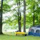 Tent and picnic setup under trees — showcases a typical tent campsite in a wooded area, useful for campers. Image is used on the Weekend Camping page of the site.