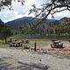 Picnic tables near lake with mountains in background