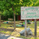 A wooden sign reading "Welcome to Bonanza Campground" stands in front of a mini golf course surrounded by trees and grass.