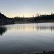Calm lake reflecting trees and sky at Trailin RV Park