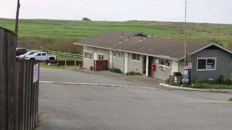 Ground-level photo of the Pelican Point RV Park office/building with surrounding green fairway visible — clearly on-site and useful to show facilities and entrance area.