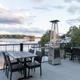 Terrace/lakeside dining area with tables and railings overlooking the lake — a clear photo of on‑site dining/riverfront amenity referenced on the site.