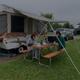 Ground-level photo of an RV/tent/camper site with a pop-up camper, picnic table and adjacent parking — illustrates typical campsite accommodations. Shown on RV/Tent/Camper Sites section.