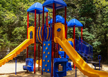 Playground equipment photograph (bright slides and climbing structures) labeled 'Playgrounds' on the site's home page — useful for family/campsite gallery.