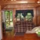 Interior view of a cabin living area (sofa, kitchenette, entry to porch) — useful for showing accommodation interior for the campground’s cottage/cabin rentals.