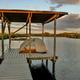 Tent on an elevated platform over water with a kayak attached