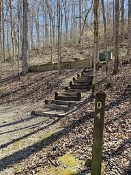 A brown post with number 4 stands below steps that lead up to the campsite.