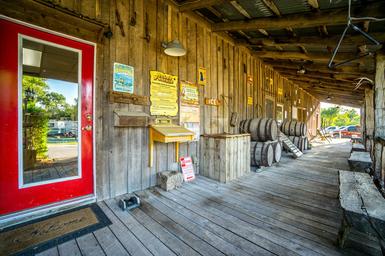 Porch/boardwalk of a rustic building on the property with decorative barrels and signage — conveys onsite amenities and style (gallery page).