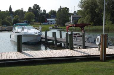 Marina/dock view with boats moored and a wooden dock — demonstrates waterfront access and recreational boating facilities referenced on the activities page.