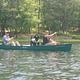 Couple taking dog for a ride in a canoe