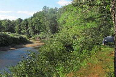 Sandy beach and picnic/table area with swimmers and docks visible — shows the campground’s beach/swim area and day-use facilities. Provided on the property’s New Hampshire page.