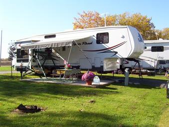 Photo of a fifth-wheel setup on a maintained grassy site with picnic table and patio — another representative RV site view showing site layout and landscaping.