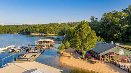 Ground-level view of the marina, guest docks, beach and restaurant building — good close-up of lakefront activity and facilities on the property (page context: 'Recreation at the Beach').