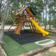 Playground equipment set among RV pads visible in background — shows family-friendly amenities and nearby campsite layout.