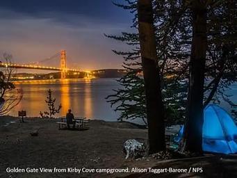 Kirby Cove at night, with the Golden Gate Bridge lit up across the bay. 