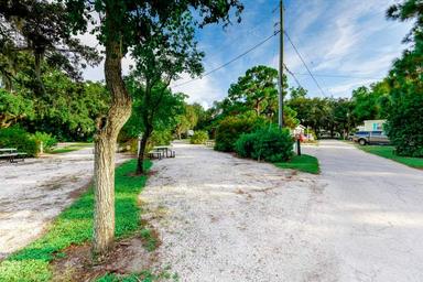 Wide view of RV sites and drive lanes with trees and utility hookups visible — useful for showing site layout; sourced from the Our Park page.
