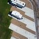 Aerial top-down shot of individual concrete RV pads with parked rigs and clear pad outlines — excellent detail of site size and configuration (from RV sites & rates page).