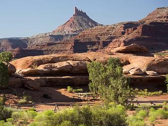 A picnic table adjacent to Hamburger Rock geologic feature with a Six Shooter peak in the background.