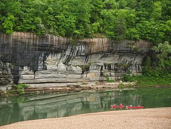Painted Bluff at Buffalo Point with two red canoes in river.