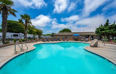 Wide shot of the resort swimming pool with surrounding lounge chairs and RV sites visible in the background — useful facility photo from the property gallery.