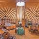 Interior of a large yurt (circular wooden frame, furnishings) — useful for showing glamping accommodation layout and ambiance (from Cozy Yurt gallery).