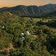 Aerial view of Zen Zion property with geodesic domes nestled among trees at golden hour