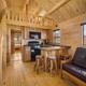Interior photograph of a rustic cabin/tiny-house kitchen and loft showing furnishings and finishes — useful to illustrate rental lodging on the property.