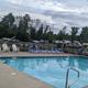 Photo showing the swimming pool with lounge chairs and RVs visible beyond the fence — useful to highlight on-site amenities (from About/Resort pages).