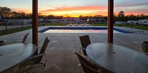 Wide view showing multiple RV sites and resort grounds from a covered/pavilion vantage; used as the RV sites hero image and provides a broad sense of the park layout and amenities.