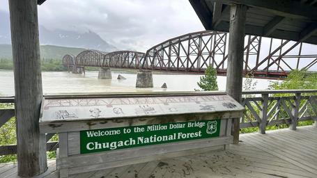 Riverside fish-cleaning table with anglers and catch at the river’s edge — corroborates the campground’s riverside fishing and processing areas shown on the site.