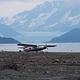 A wheeled airplane parked on the beach after landing near the cabin. A beach plane landing depends on the tide and if there are icebergs on the beach.