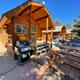 Close view of KOA-style wood cabin with porch, picnic table and grill — a clear photo of on-site cabin accommodations consistent with the campground’s ‘ways to stay’ images.
