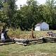 A historic one room schoolhouse at Alley Spring with garden and scarecrow in the foreground