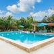 Clear daytime photograph of the main outdoor swimming pool, pool deck and lounge furniture — matches the site’s pool/gallery content and labeled as the community pool.