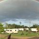 Panoramic ground-level view of RV sites across the campground with visible amenities and landscaping; useful for showing campsite atmosphere (homepage banner).