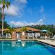 Wide-angle pool view showing pool, fenced deck, palm trees and resort structures; file is used as the Blue Parrot RV Resort social image on the property page, indicating it depicts the resort.