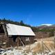 Brown cabin surrounded by green trees and rolling landscape