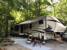 RV campsite photo (fifth-wheel, patio setup) from the site gallery — useful depiction of typical RV pitch and guest setup.