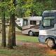 Photograph of RVs parked among trees on grassy pads — good depiction of the campground’s RV sites and layout (used in 'Ways To Stay' / campsites section).
