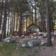 Cabin among trees: elevated cabin set on rocky ground with surrounding pines — useful to show cabin variety and wooded setting (from Contact page gallery).