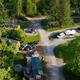 Aerial view showing campground layout with RVs, cabins, drive lanes and a central fire pit area; matches site hero/social video still on the property page.