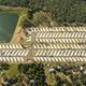 Clear aerial overview showing the full RV resort layout with rows of concrete pads and the large pond; matches site homepage imagery and gives overall property context.