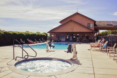 Pool and clubhouse view with hot tub in foreground and building behind — useful amenity photo matching the Amenities page showing on-site pool and guest facilities.