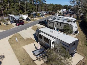 Ground-level/drone image showing individual concrete RV pads and hookups — useful to illustrate campsite amenities and pad layout (gallery drone image of on-site spaces).