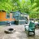 Cabin exterior with Adirondack chairs and a fire ring — clearly shows a cabin site and adjacent grounds from the campground's lodging photos.