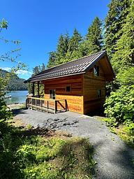 View of the side and back of Anan Bay Cabin with bay and boats in background.
