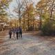 Wide panoramic shot showing walking paths, tents/cabins and wooded grounds with people walking — good overall view of campsite layout and accommodation types on property.